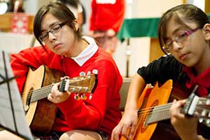 Arley Melendez, left, and Jacqueline Gutierrez play guitar during a recent school Mass at Notre Dame Middle School, Milwaukee. (Submitted photo courtesy Notre Dame Middle School)