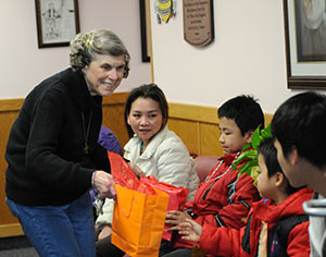 Mary Jo Copeland, founder of Sharing and Caring Hands, gives welcome bags to members of a new family in Minneapolis, Feb. 11. (CNS photo/Dianne Towalski, Catholic Spirit)