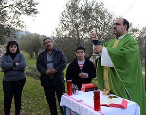 Fr. Ibrahim Shomali celebrates an outdoor Mass in an olive grove outside the Salesian Monastery in Beit Jalla, West Bank, Jan. 18. A planned routing of the Israeli separation barrier could isolate the monastery from the people it serves.  (CNS photo/Debbie Hill)