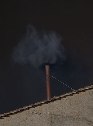 Black smoke billows from the chimney of the Sistine Chapel, the sign that cardinals did not elect a pope in their first round of balloting March 12 at the Vatican. (CNS/Paul Haring)