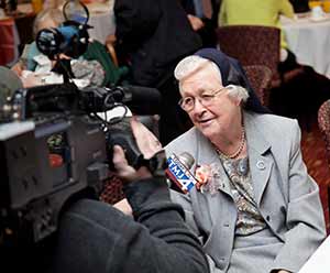 Franciscan Sr. Camille Kliebhan speaks with a television reporter during her 90th birthday celebration at Cardinal Stritch University, Milwaukee, in April. Currently chancellor of the university, Sr. Camille has been with the school since 1955. (Submitted photo by Kou Vang, courtesy Cardinal Stritch University)