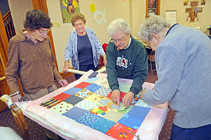 Jean Forsterling looks on as members of the group who meet every Monday work together on a quilt. (Catholic Herald photos by Sam Arendt)