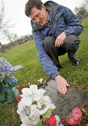 Patrick Jordan, former managing editor of the Catholic Worker newspaper, brushes wet leaves from Dorothy Day’s grave marker at Cemetery of the Resurrection in the Staten Island borough of New York Dec. 9, 2012. Jordan and his wife Kathleen were close associates of Day, co-founder of the Catholic Worker movement. (CNS photo/Gregory A. Shemitz)