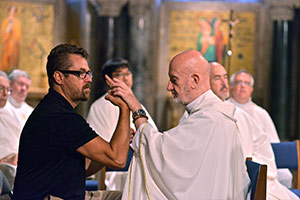 Redemptorist Fr. Cyril Axelrod of London, right, who is both deaf and blind, participates in a July 16 Mass in the crypt church of the Basilica of the National Shrine of the Immaculate Conception, assisted by David Day, during a gathering of the International Catholic Deaf Association in Washington. (CNS photo/Michael Hoyt, Catholic Standard)