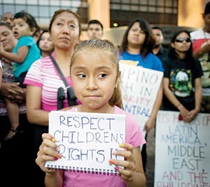 A girl holds a sign during a 2014 vigil and rally in support of the flood of undocumented Central American minors apprehended along the U.S.-Mexico border. A new report says less than 1 percent of Central American children apprehended by Mexican immigration officials are able to obtain asylum in Mexico. (CNS photo/David Maung, EPA)