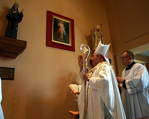  Archbishop Jerome E. Listecki blesses a new Divine Mercy worship area at St. Anne Parish, Pleasant Prairie, on Sunday, April 3. The area includes a large print of Divine Mercy and Italian-crafted statues of St. Faustina and St. John Paul II. At left, the statue of St. John Paul II is readied for installation. (Submitted photo at left; above Catholic Herald photo by Allen Fredrickson)