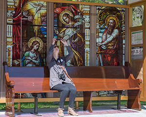 Lindsey Mushall, executive assistant for the St. Josaphat Basilica Foundation, takes a picture of the bus shelter ceiling at the corner of Jackson and Wells streets, Milwaukee, Wednesday, May 18. The shelter, designed to resemble the basilica – including its domed ceiling – is part of the foundation’s effort to raise $7.5 million for exterior repairs. (Catholic Herald photo by Peter Fenelon)