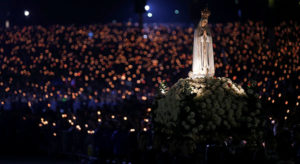 A statue of Our Lady of Fatima is carried through the crowd May 12 at the Marian shrine of Fatima in central Portugal. Thousands of pilgrims arrived at the shrine to attend the 99th anniversary of the first apparition of Mary to three shepherd children. Lucia dos Santos and her cousins, Francisco and Jacinta Marto, received the first of several visions May 13, 1917. (CNS photo/Rafael Marchante, Reuters)