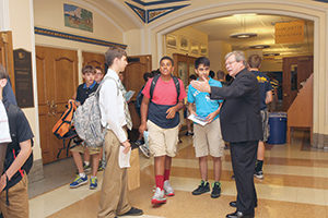 Jesuit Fr. Warren Sazama chats with Marquette University High School students in the hallway of the all-boys school. (Submitted photo courtesy Visual Image Photography)