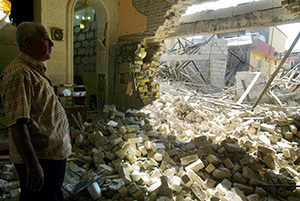 An Iraqi man inspects the damage in 2011 at a Catholic church after attacks in Kirkuk. Despite predictions that Christianity could be wiped out of his war-torn homeland within five years, Chaldean Archishop Yousif Mirkis of Kirkuk said he believes in God's ultimate preservation. (CNS photo/Khalil Al Anei, EPA)