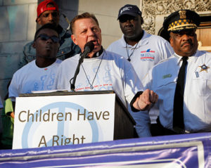 Fr. Michael Pfleger, pastor of St. Sabina Parish in Chicago, speaks to participants during a June 17 rally and march in front of his parish church to kick off the beginning of summer and call for an end to violence in their community (CNS photo/Karen Callaway, Catholic New World)