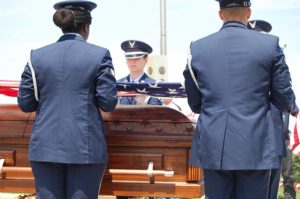 Members of the Air Force honor guard prepare to fold the American flag over the casket of Thomas Condon who died in a plane crash enroute to Alaska in 1952. The wreckage wasn’t discovered until 2012. 