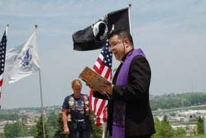 Following a Mass of Christian Burial for Thomas Condon at St. Joseph, Waukesha, the parish’s pastor, Fr. Javier Bustos, reads the Rite of Committal at St. Joseph Cemetery on Wednesday, May 25. 