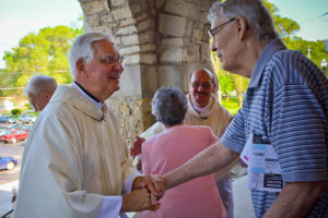 Fr. Richard Mirsberger, foreground, and Fr. Joseph Hornacek, rear, greet parishioners at St. Catherine of Alexandria, Milwaukee, following the Saturday, May 28 Mass at which the friends and seminary classmates celebrated their 50th anniversary of priesthood ordination. 