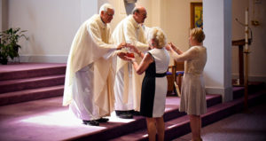 The priests accept the offertory gifts from parishioners. Frs. Mirsberger and Hornacek, who have known each other for 56 years, serve as co-assisting priests at the parish. (Catholic Herald photos by Juan C. Medina)