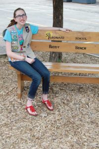 Carolyn Kopp, a sophomore at Muskego High School, Muskego, and graduate of St. Leonard School, Muskego, sits on the buddy bench she arranged to have installed at St. Leonard as part of her Girl Scout Gold Award. (Catholic Herald photo by Ricardo Torres)