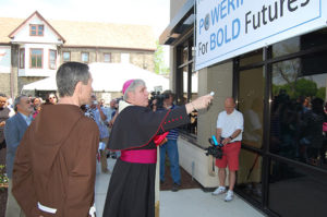 With Capuchin Fr. Michael Bertram, pastor of St. Francis of Assisi Parish, Milwaukee, on his right, Archbishop Jerome E. Listecki blesses the TechForce Training Center on the St. Francis of Assisi Parish campus on Tuesday, May 24.