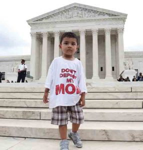 A boy wearing a T-shirt reading “Don’t Deport My Mom” stands outside the U.S. Supreme Court in Washington June 23 after the justices issued a 4-4 ruling on President Barack Obama’s executive actions on immigration. The split decision leaves in place a lower court ruling that blocked Obama’s policies. (CNS photo/Andrew Gombert, EPA)
