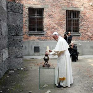 Pope Francis places a candle in front of the wall of death as he visits the Auschwitz Nazi death camp in Oswiecim, Poland, July 29. (CNS photo/Paul Haring) 