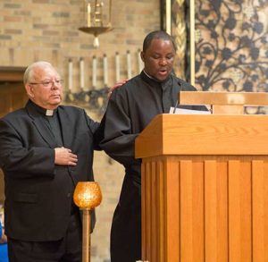 Simon Muema, right, makes his first profession of vows as a Salvatorian on Sunday, Aug. 14, at St. Pius X Church, Wauwatosa. (Catholic Herald photo by Peter Fenelon)