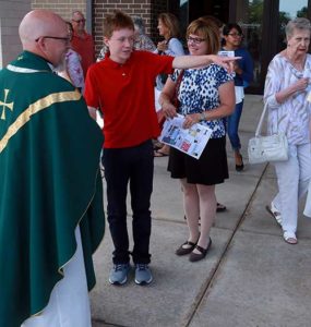 Nicholas Livingston, 14, talks with Fr. Robert Weighner following Mass at St. Anne, Pleasant Prairie. His mother Julie Livingston listens to the conversation.