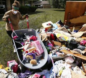 Melissa Gouda removes flood damaged items out of a friend’s house in St. Amant, La., Aug. 21. Historic flooding in southern Louisiana killed at least 13 people and damaged an estimated 60,000 homes, said state officials. (CNS photo/Jonathan Bachman, Reuters)