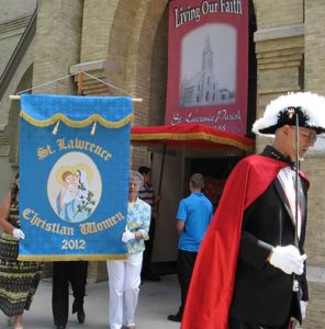During the 2012 St. Lawrence feast day celebration at St. Lawrence Parish, Hartford, Christian Women, Ree Koth, left, and Darlene Hefter, carry the organization’s new banner in the Eucharistic procession. The group is celebrating its 125th anniversary in October. (Submitted photo courtesy St. Lawrence Parish archives)