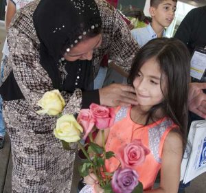 Mehidia Mahmoud, left, a member of a family of Kurdish refugees who fled to Turkey from Syria’s civil war, greets the daughter of friends in Nashville, Tenn. She is among a group of refugees who relocated to Nashville Aug. 30. (CNS photo/Theresa Laurence, Tennessee Register)