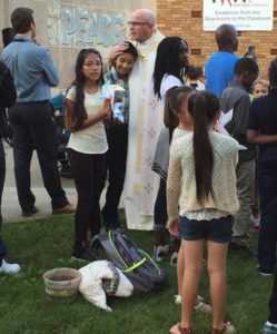 Fr. Mike Barrett, pastor at Our Lady of Good Hope Parish, Milwaukee, visits with Northwest Catholic School students prior to a Sept. 16 dedication ceremony of the Peace Garden created in memory of former student, Laylah Petersen. (Catholic Herald photo by Colleen Jurkiewicz)