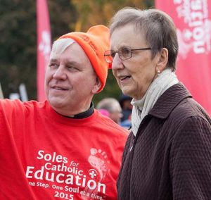 Archbishop Jerome E. Listecki and Kathleen Cepelka, superintendent for schools, chat during the 2015 Soles for Catholic Education walk at Mount Mary University, Oct. 17. (Submitted photo courtesy the Milwaukee Archdiocesan Communications Department)