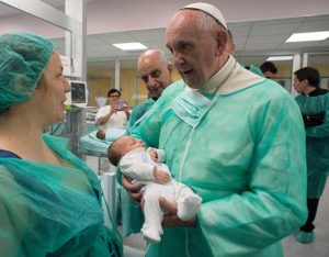 Pope Francis holds a baby as he visits the neonatal unit at San Giovanni Hospital in Rome Sept. 16. The visit was part of the pope’s series of Friday works of mercy during the Holy Year. (CNS photo/L’Osservatore Romano, handout)