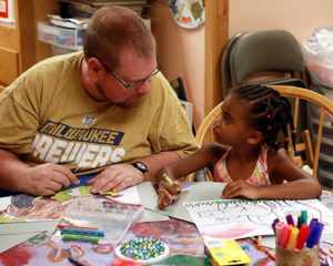 Coloring is one of the activities that adults and children at the St. Ann Center for Intergenerational Care, Milwaukee, do together. Above, Mike McFarlane and 4-year-old Dineen Renno work on their projects together, Monday, July 25. (Catholic Herald photo by Allen Fredrickson)