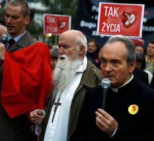 A clergyman and others pray as they take part in Sept. 22 pro-life rally in front of the parliament in Warsaw, Poland. Banners read: “Yes for life.” (CNS photyo/Kacper Pempel, Reuters)