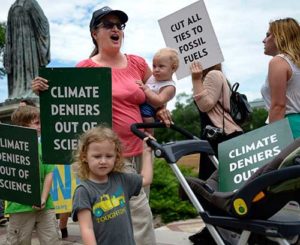 Protesters chant and display signs in front of the Smithsonian Castle during a 2015 anti-fossil fuel rally in Washington. Citing Pope Francis’ encyclical “Laudato Si’” on humanity’s relationship with the earth and each other, seven Catholic institutions from around the world said they plan to divest from fossil fuel corporations. (CNS photo/Shawn Thew, EPA)
