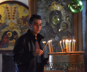 Sezer Abu Shkara, An Arab Catholic from Haifa, Israel, lights a candle in the Church of Nativity, where tradition holds  Christ was born in Bethlehem, West Bank. Few tourists are visiting Bethlehem this Christmas season because of the recent violence between Israelis and Palestinians. (CNS photo/Debbie Hill)