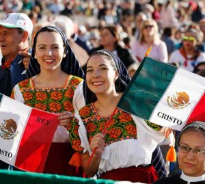 Women in traditional Mexican dress hold flags before the canonization Mass for seven new saints celebrated by Pope Francis in St. Peter's Square at the Vatican Oct. 16. Mexican St. Jose Sanchez del Rio was among those canonized. (CNS photo/Paul Haring)
