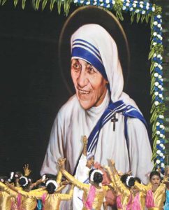 Young women from Missionaries of Charity homes in Kolkata, India, dance near an image of St. Teresa of Kolkata during an Oct. 2 celebration in her honor at the Netaji Indoor Stadium. Pope Francis canonized her Sept. 4 at the Vatican. (CNS photo/Anto Akkara)