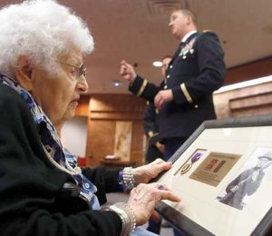 Florence Adamski Gaszak examines the framed Purple Heart, which also includes a photo of her father, Boleslaw (Bill) Adamski, who was awarded the medal for his service in World War I. (Catholic Herald photo by Allen Fredrickson)