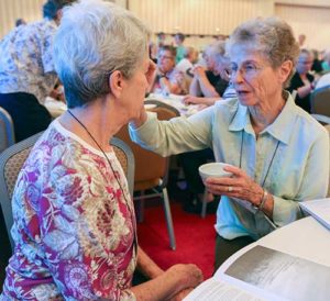 Sr. Marietta Fahey, a member of the Sisters of the Holy Family from Freemont, Calif., right, signs the forehead of Sr. Madeleine Meagher, a member of the Religious Sisters of Charity from San Pedro, Calif., Aug. 10 during the Leadership Conference of Women Religious assembly in Atlanta. Thanks to a foundation grant, CARA will study religious sisters’ life, ministry (CNS photo/Michael Alexander, Georgia Bulletin)