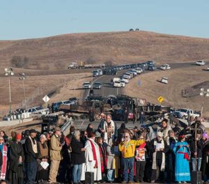 Clergy of many faiths from across the United States participate in a prayer circle Nov. 3 in front of a bridge in Standing Rock, N.D., where demonstrators confront police during a protest of the Dakota Access pipeline. Demonstrations against the pipeline are taking place on the Standing Rock Indian Reservation near Cannonball, N.D. (CNS photo/Stephanie Keith, Reuters)