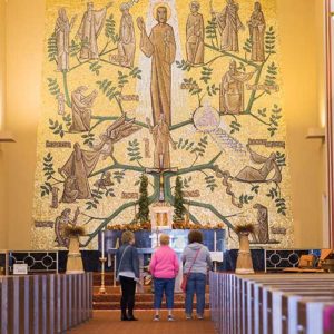 Visitors to Immaculate Conception Church, Milwaukee, examine the altar and painting on the wall.