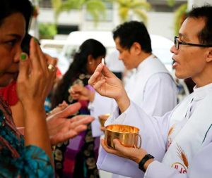 Faithful receive Communion in Bangkok Dec. 25, 2015. Four cardinals said they formally asked Pope Francis to clarify his teaching on Communion for the divorced and civilly remarried and have not received a response in two months. (CNS photo/Diego Azubel, EPA) 