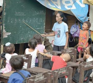 Indigenous children displaced by paramilitary violence attend school in late August in a makeshift classroom in a church compound in Davao, on the southern Philippine island of Mindanao. Hundreds of indigenous are living in the church center, afraid to return home. (CNS photo/Paul Jeffrey)  