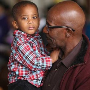 A father holds his son during Mass Nov. 13 at St. Peter Claver Church in Baltimore. The U.S. bishops will concelebrate Mass at the church Nov. 14, the first day of their fall general assembly. (CNS photo/Bob Roller)