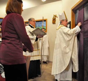 Archbishop Jerome E. Listecki starts unsealing the Holy Door at St. Charles Parish, Hartland, Dec. 8, 2015, to begin the Jubilee Year of Mercy in the Milwaukee Archdiocese. The Year of Mercy, as designated by Pope Francis, will end on Sunday, Nov. 20. (Catholic Herald photo by John Kimpel) 